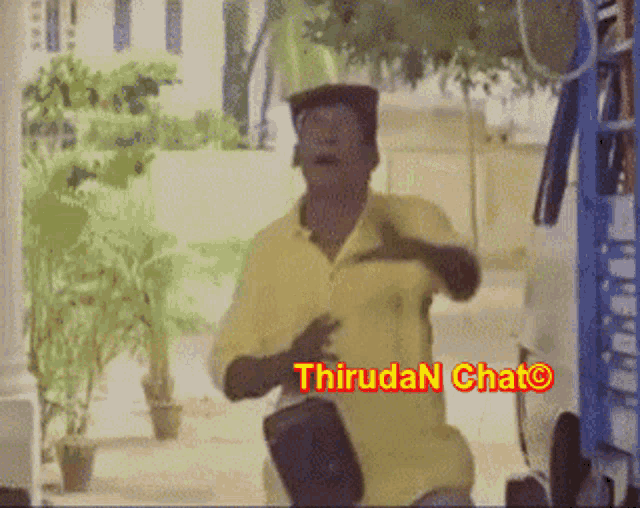 a man in a yellow shirt is dancing in front of a sign that says thirudan chato