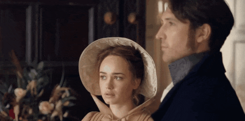 a man and a woman are standing next to each other in a room