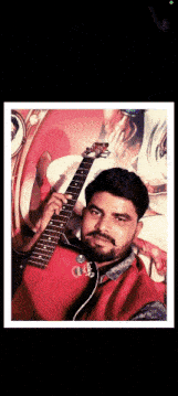 a man in a red jacket holds a guitar