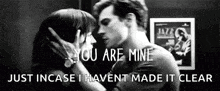 a man and a woman are kissing in a black and white photo with a caption that says `` you are mine '' .