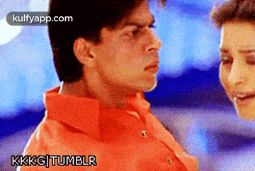 a man in an orange shirt looks at a woman in a blue shirt