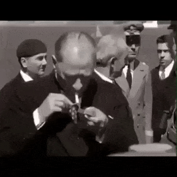 a man in a suit and tie is smoking a cigarette