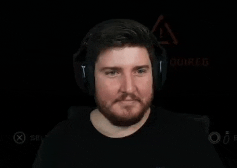a man with a beard wearing headphones is laughing and waving .