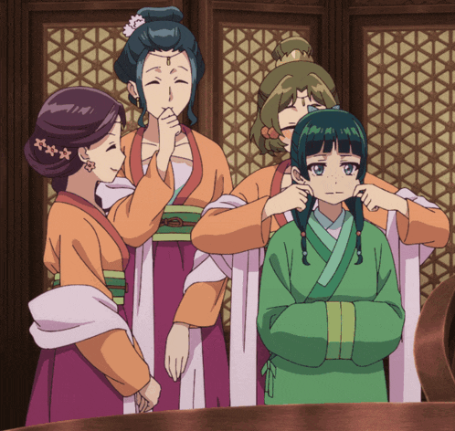 a group of women are standing around a young girl in a green dress