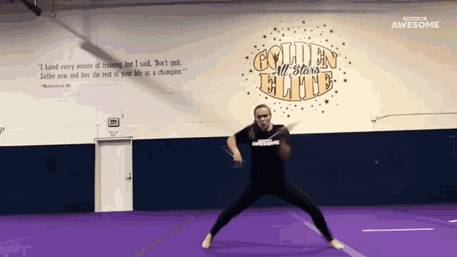 a woman stands in front of a sign that says golden all star elite
