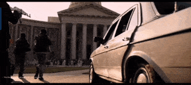 a car is parked in front of a building with a sign that says " this part of the movie is not allowed to be seen "