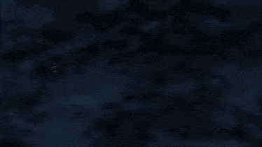 a red white and blue robot is flying in the dark