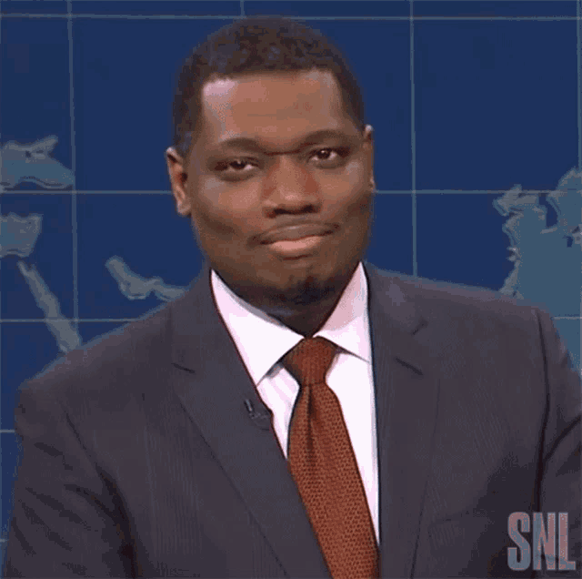 a man in a suit and tie with snl written on the bottom