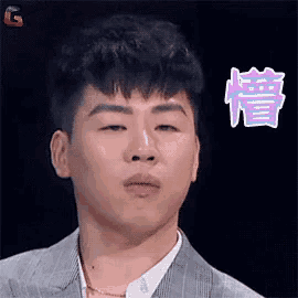 a man in a suit and white shirt is making a funny face with chinese writing on it .