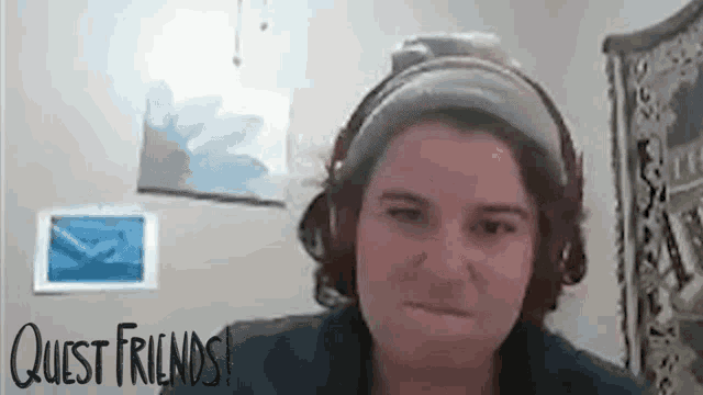 a woman wearing headphones is making a funny face while talking on a video call .