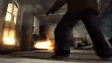 a man is standing in a room with a fire coming out of it .