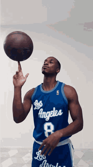 a man in a blue los angeles jersey is holding a basketball