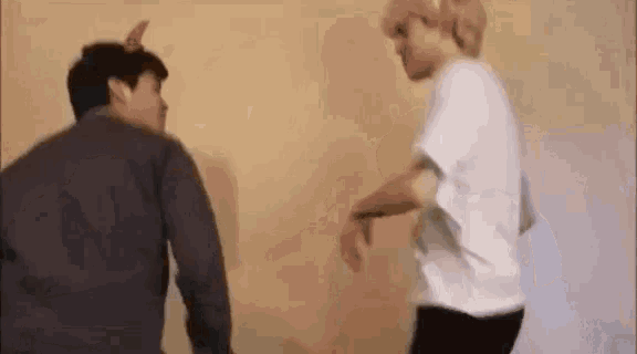 a couple of men are standing next to each other and dancing .