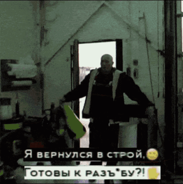 a man is standing in a dark room with a sign that says " я вернулся в строй готовы к разь бу "