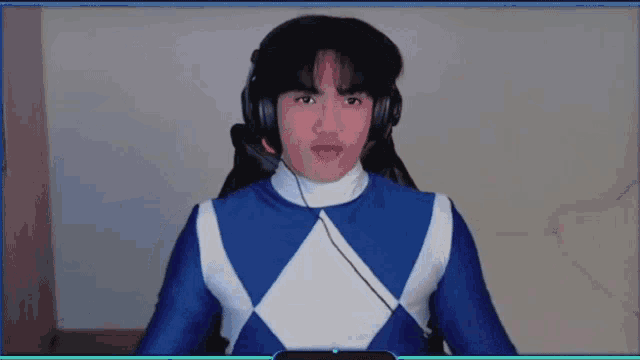 a young man in a blue and white power ranger costume is wearing headphones .