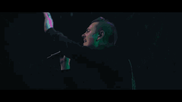 a group of people playing instruments on a stage with green lights