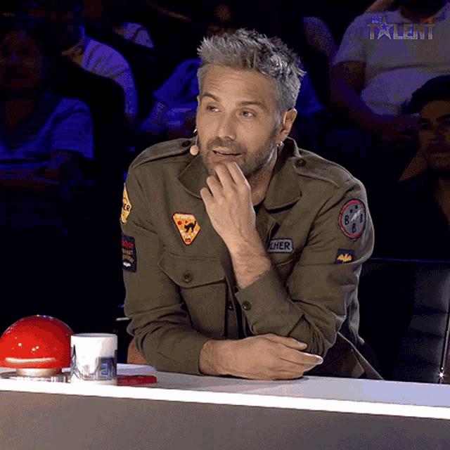 a man wearing a khaki jacket with the word cher on the back