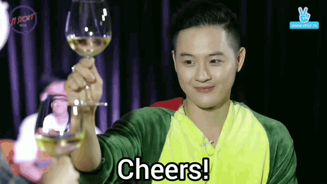 a man holding a wine glass with the words cheers written on it