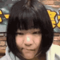 a girl with short hair and a nose ring is making a face .