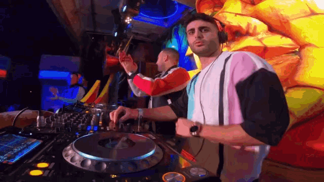a man wearing headphones is playing music on a turntable in a dark room