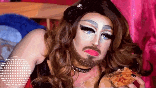 a drag queen with a beard and makeup is eating pizza .