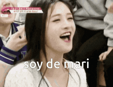 a woman is laughing with the words soy de mari written on her face .