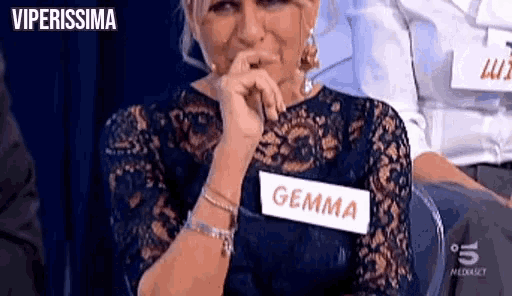 a woman wearing a name tag that says gemma is sitting in a chair .
