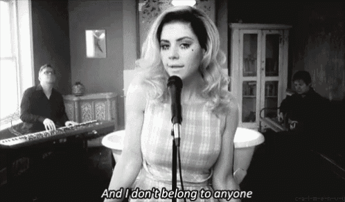 a woman singing into a microphone with the words " and i don 't belong to anyone " written below her