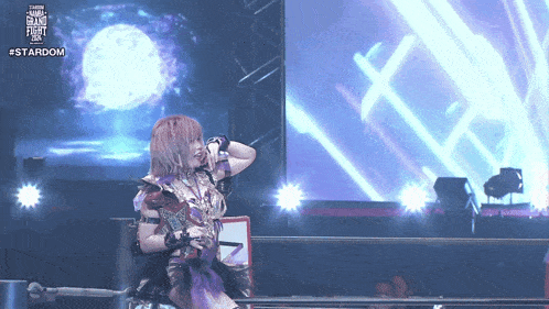 a woman in a wrestling ring with the word stardom on the bottom right corner