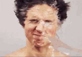 a close up of a man 's face with water pouring on it