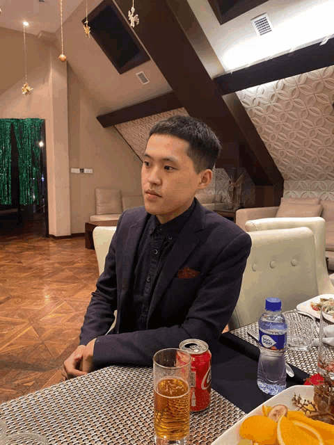 a man sits at a table with a can of coca cola