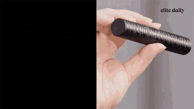 a close up of a person 's hand holding a mascara tube with elite daily written in the corner