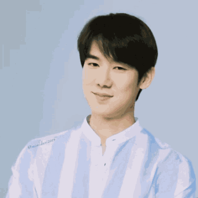 a man wearing a blue and white striped shirt has the year 2019 written on his sleeve