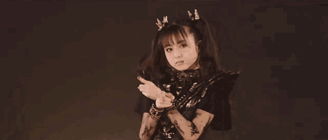 a woman with pigtails is making a peace sign with her hands