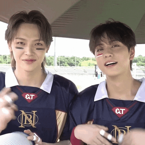 two boys wearing jerseys with the letters rt on them