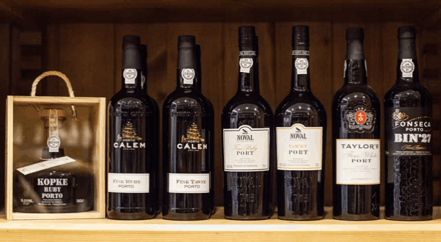 several bottles of wine are lined up on a shelf including taylor 's fine white port