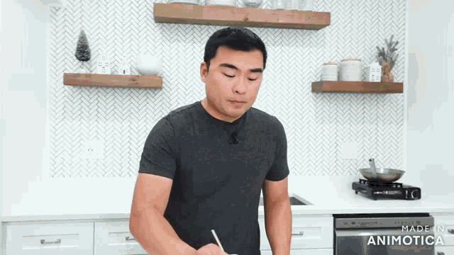 a man in a gray shirt is standing in a kitchen with the words made in animatica on the bottom right