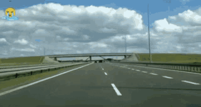 a car is driving down a highway with a crying face on the bottom right