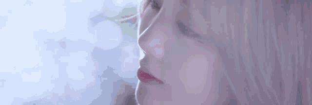 a close up of a woman 's face with smoke coming out of it .