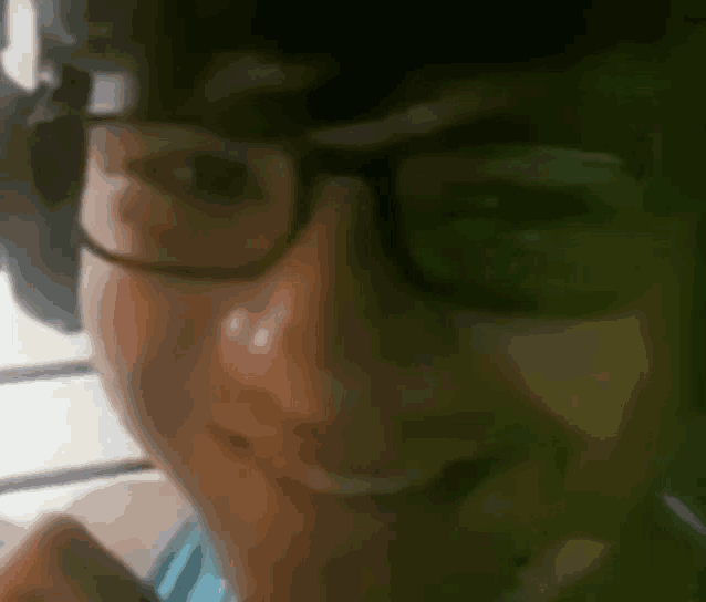 a close up of a person 's face wearing glasses
