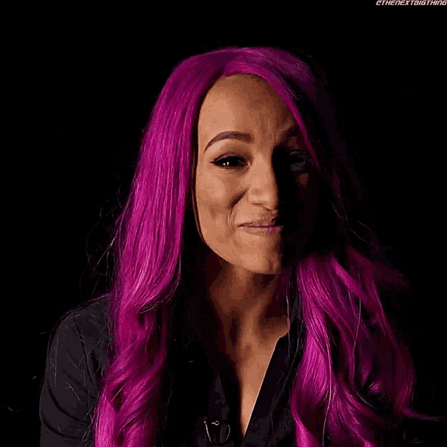 a woman with purple hair is making a funny face .