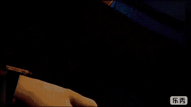 a person is brushing their teeth with a green toothbrush in the dark .