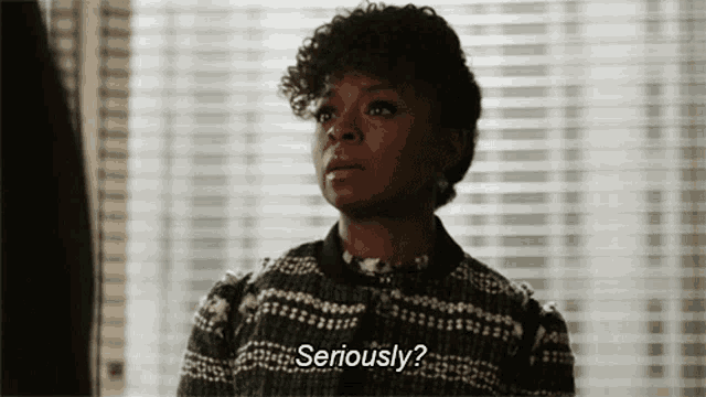 a woman wearing a sweater says seriously