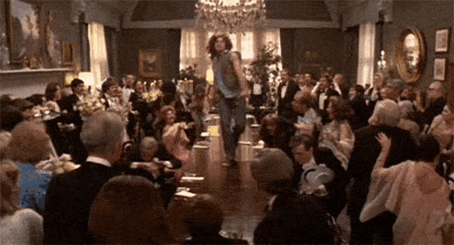 a woman is walking down a runway in front of a crowd of people at a party .