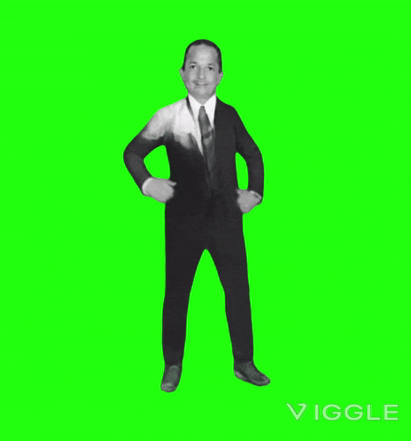 a man in a suit is dancing on a green screen