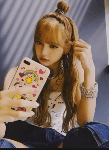 a woman is taking a selfie with her phone while sitting on the floor .