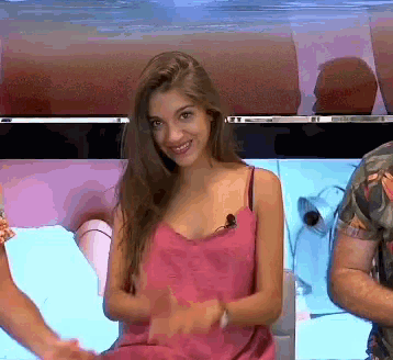 a woman in a pink tank top with a microphone on her neck