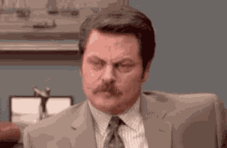 a man in a suit and tie is making a funny face