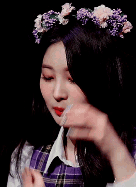 a woman wearing a purple plaid shirt and a flower crown