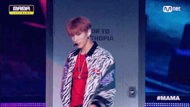 a man in a zebra print jacket is on a stage in front of a sign that says ethiopia